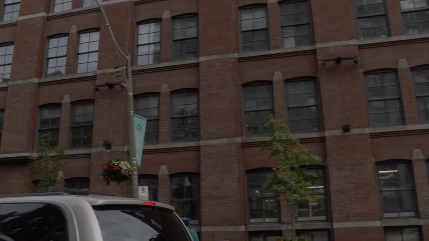 While moving along an urban street multiple cars and pedestrians are seen as a bicyclist pedals along