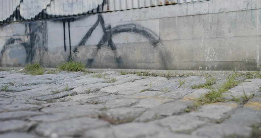 Two people walking outside past a wall with graffiti