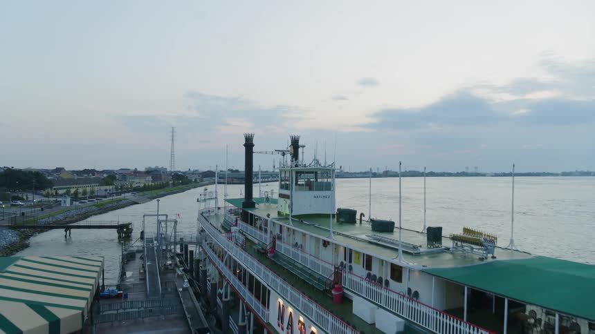 A ferry sits by a pier in an ocean next to a city
