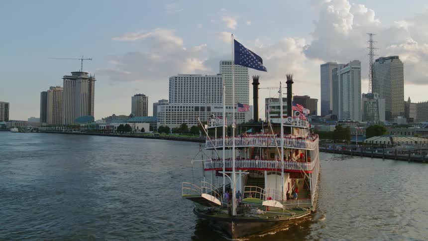 The ferry full of people leaves the pier in the city at sunset