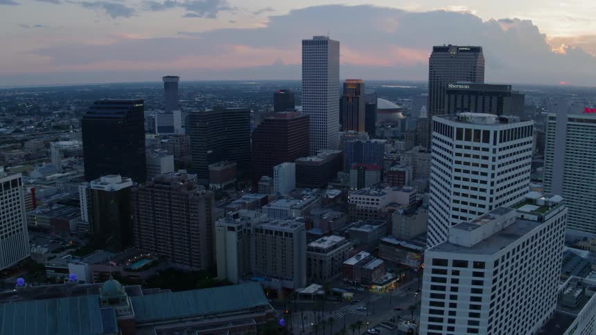 Skyscrapers and buildings stand in a city at sunset