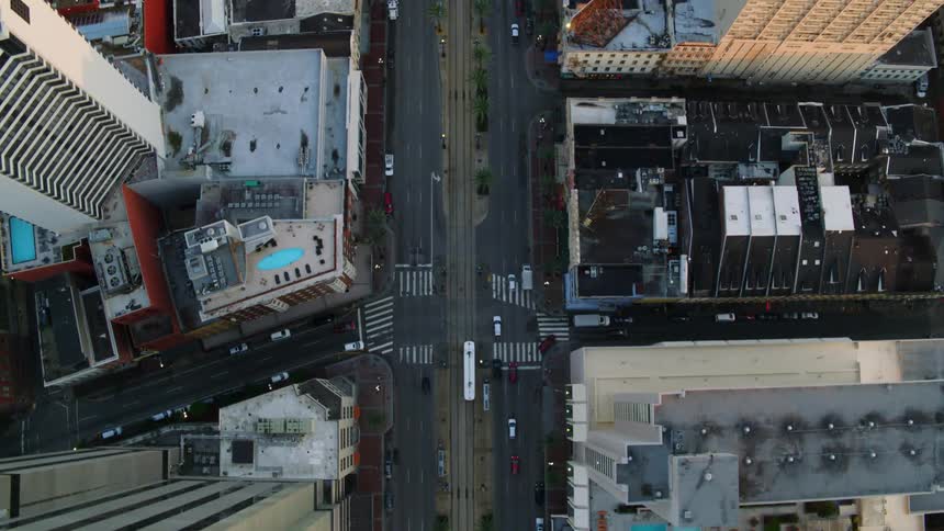 Cars drive by skyscrapers and buildings on a city street