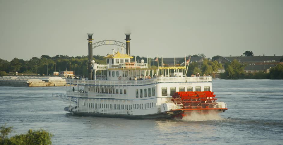 A paddle powered ferry travels down a river