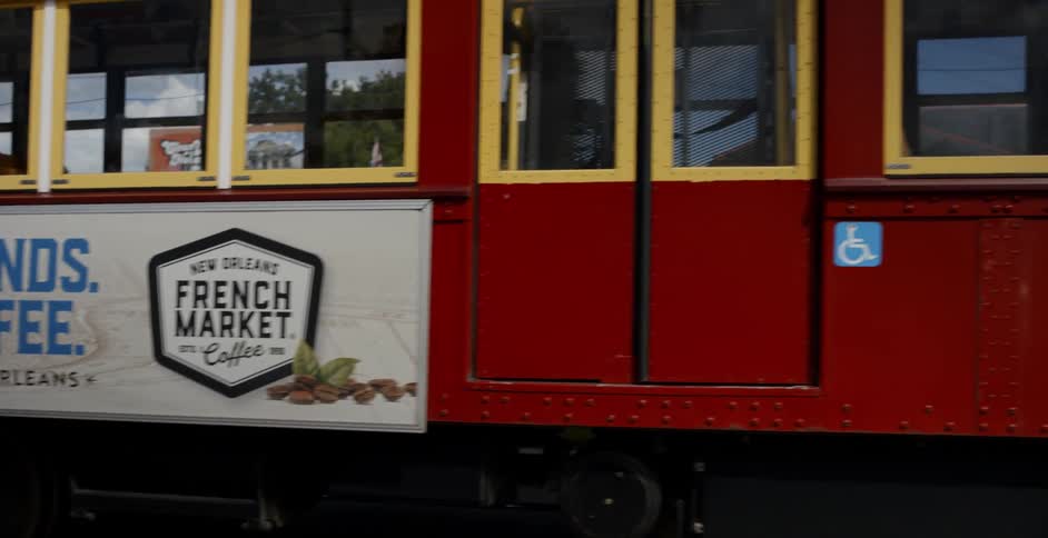 Trolley car with advertising on its side travels down the tracks