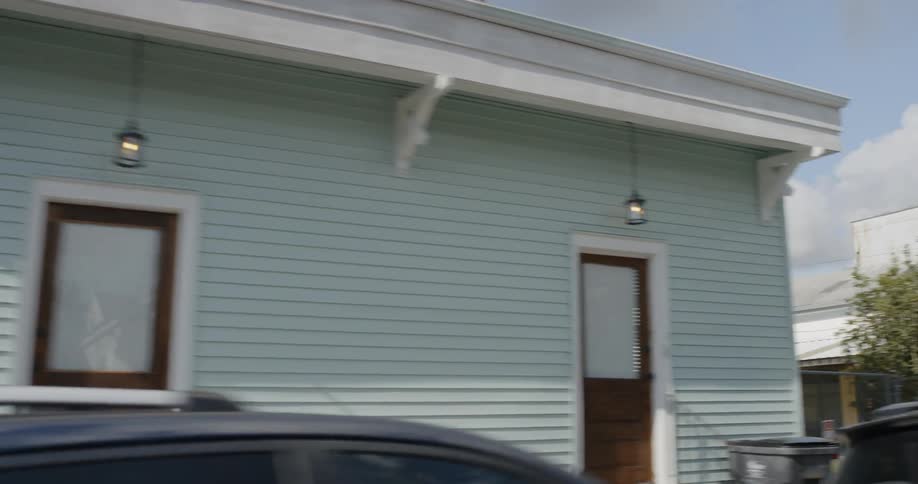 A car drives by colorful houses in a neighborhood