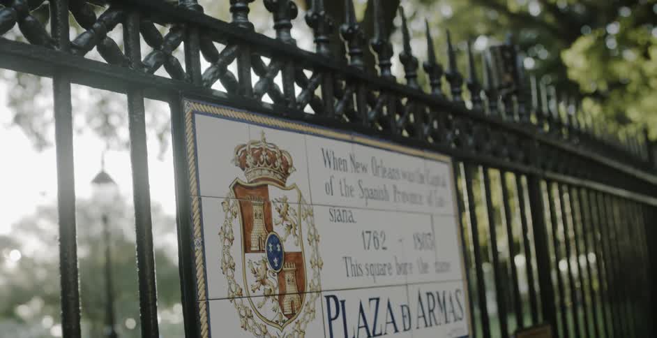 The wrought iron fence with decorative spikes along the top has a plaque showing the name of the square