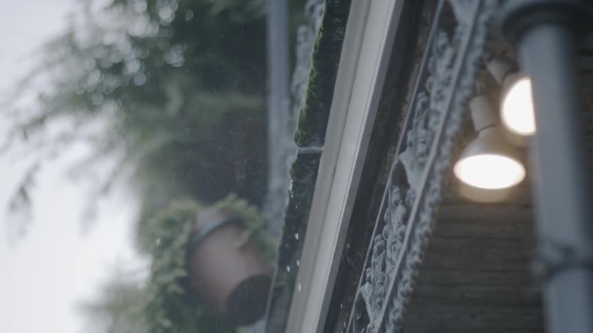 Looking up at a ledge with plants and water falling down