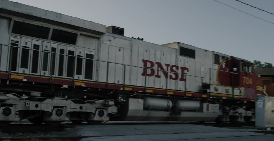 Cargo train passing by a crossing in its way to the city
