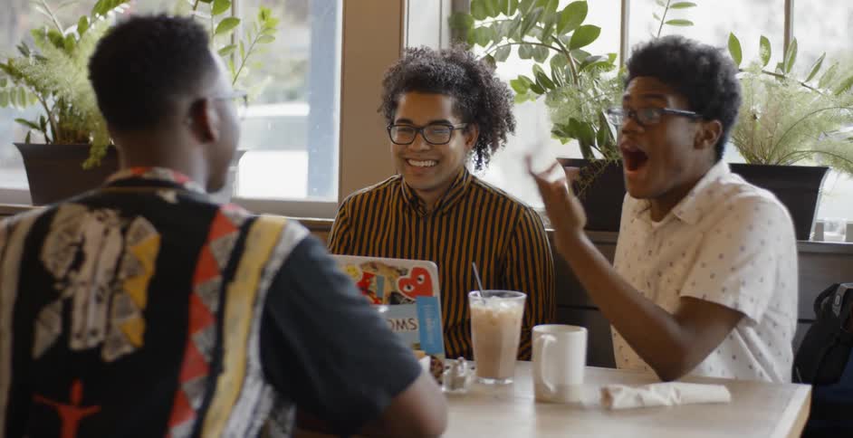 Friends sit in coffee shop enjoying themselves