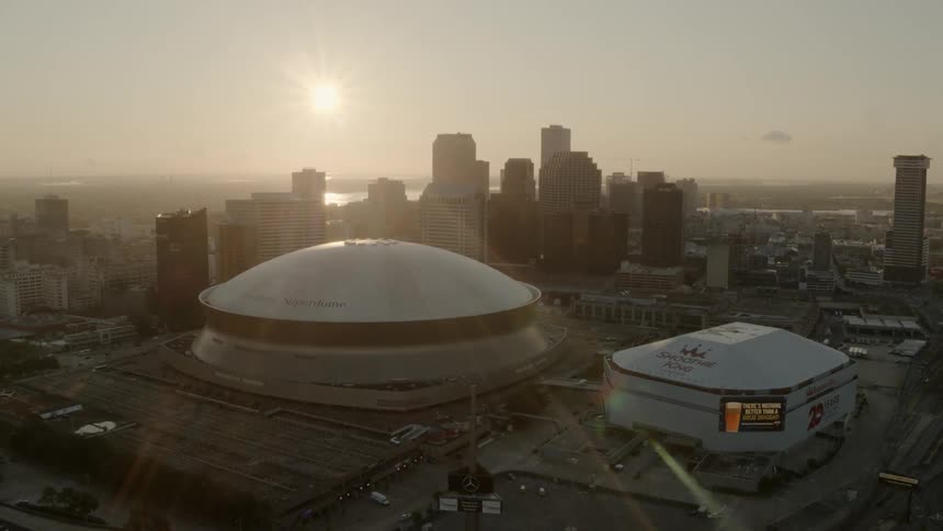 The sun sets behind a city