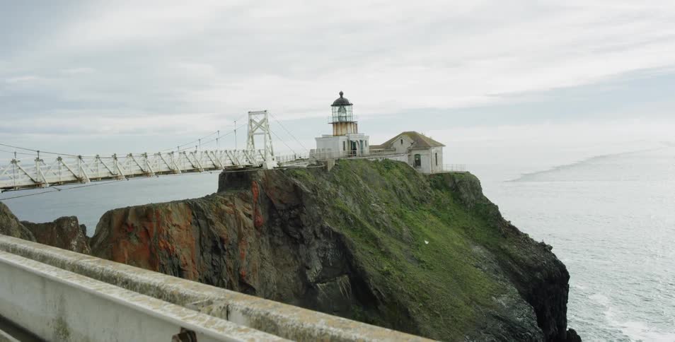 A lighthouse is on a cliff by the ocean