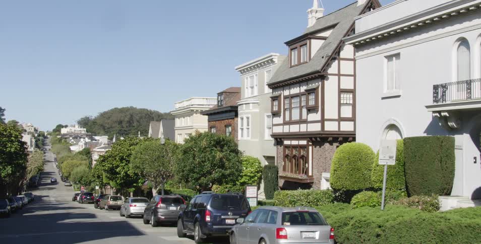 Cars are parked on the side of roads in a neighborhood