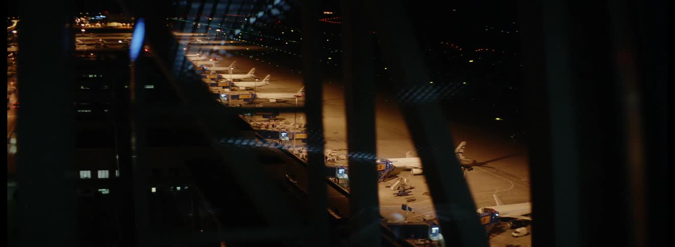 An airport tarmac with several parked airplanes