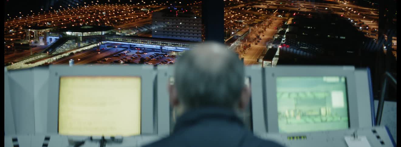 Man sit in front of computers in the air traffic control tower