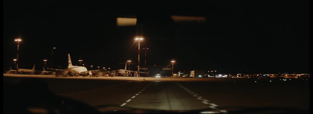 A vehicle driving down a road near an airport