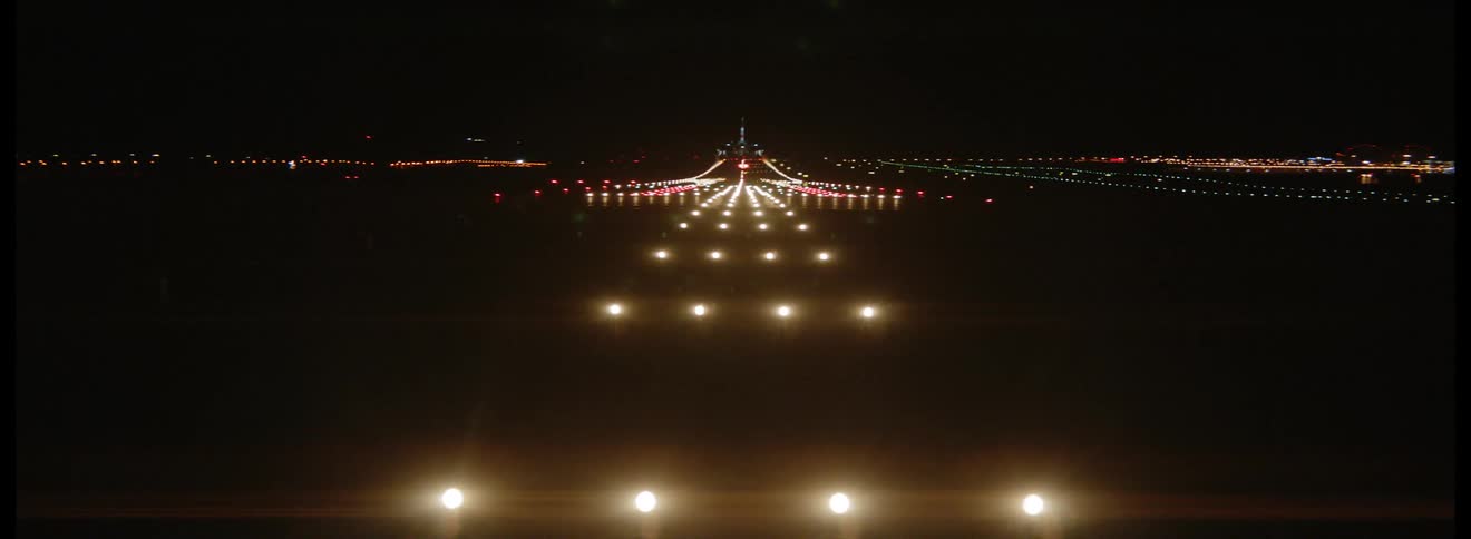 Airplane landing on a lit up runway at night