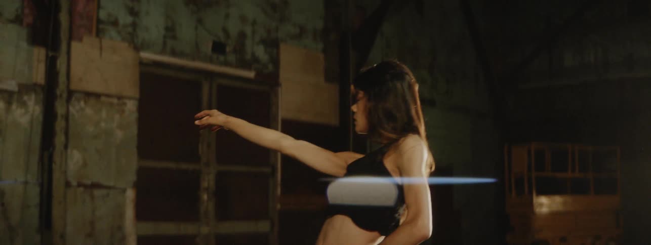 Woman dances very passionately in front of a light
