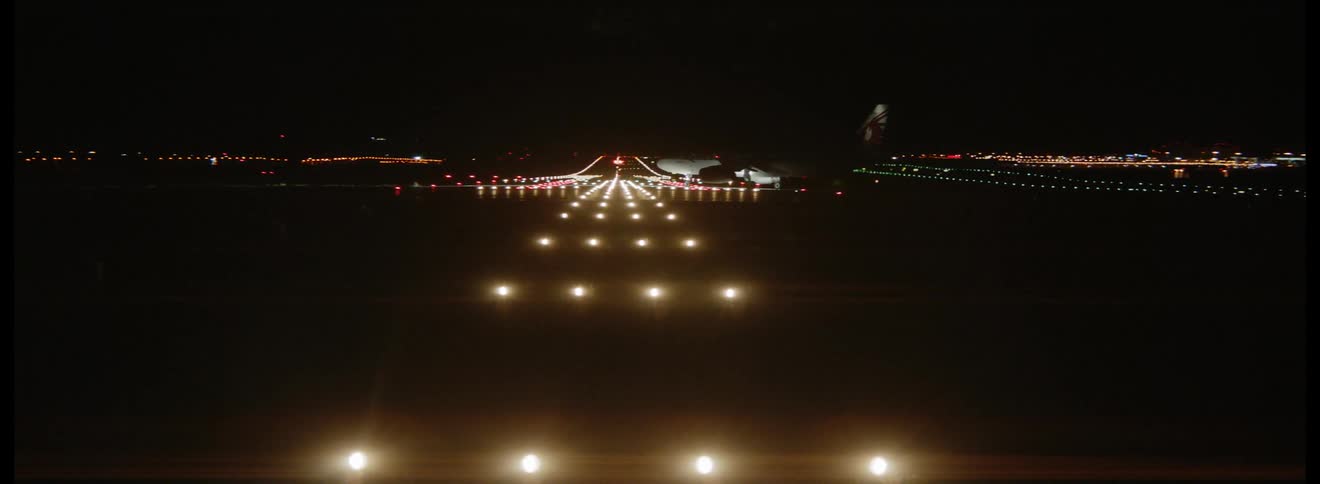 Airplane taxiing on a lit runway at night