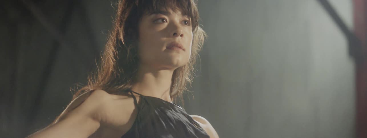 Tight shot of woman dancing in dim room