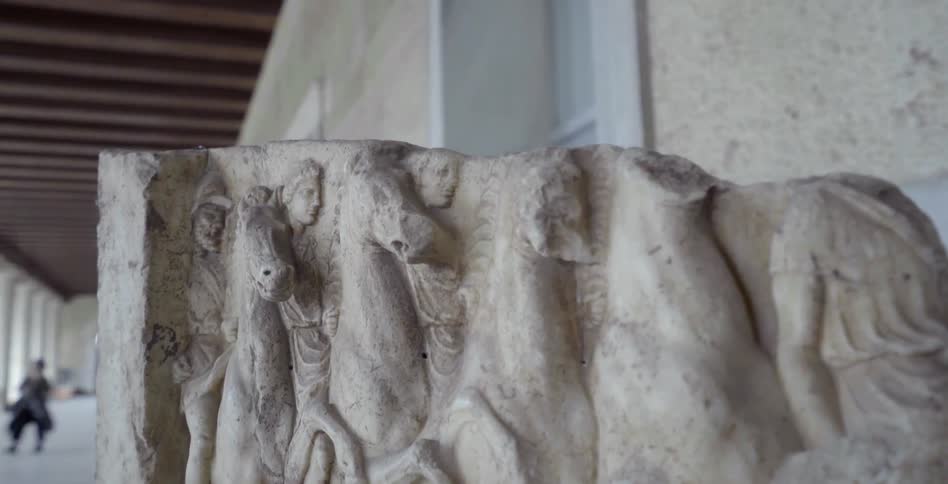An ancient carving sits next to a building