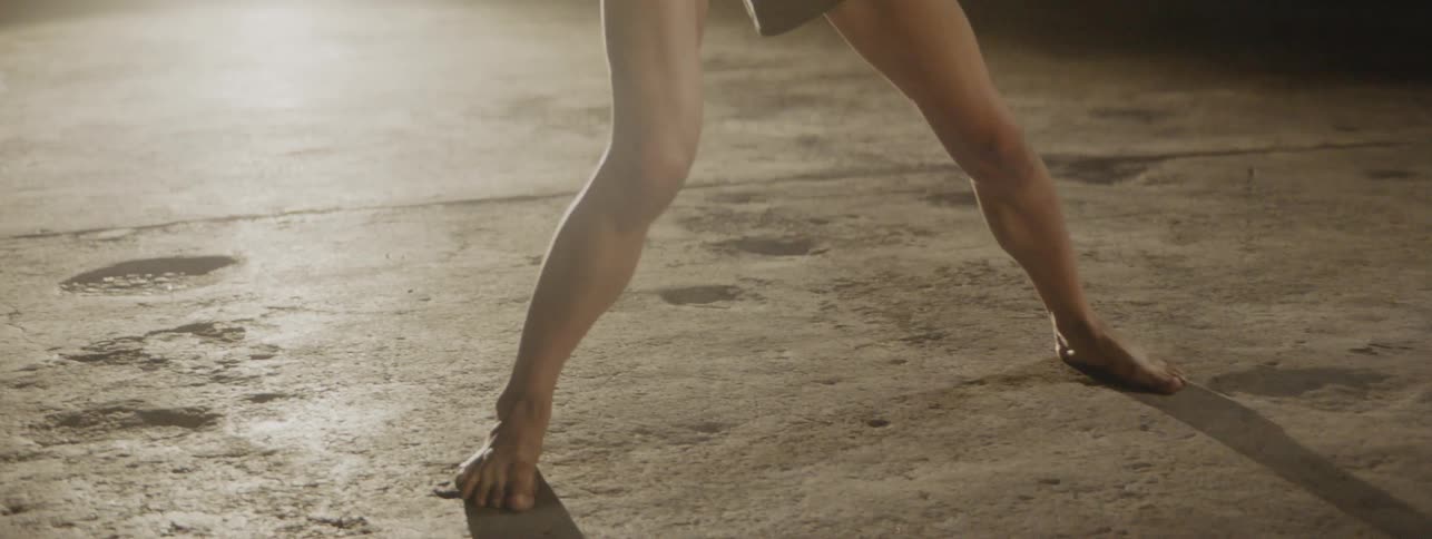 A female dancing and performing ballet movements in an empty warehouse