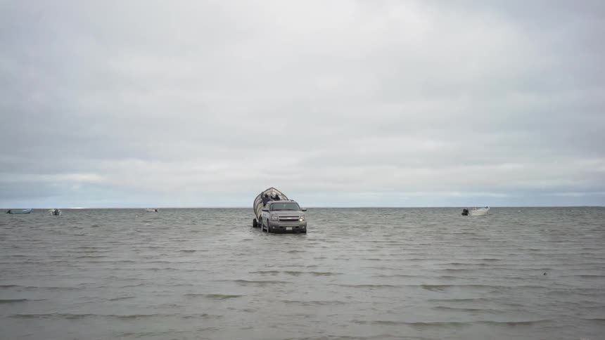 Car with boat dock sits in shallow water