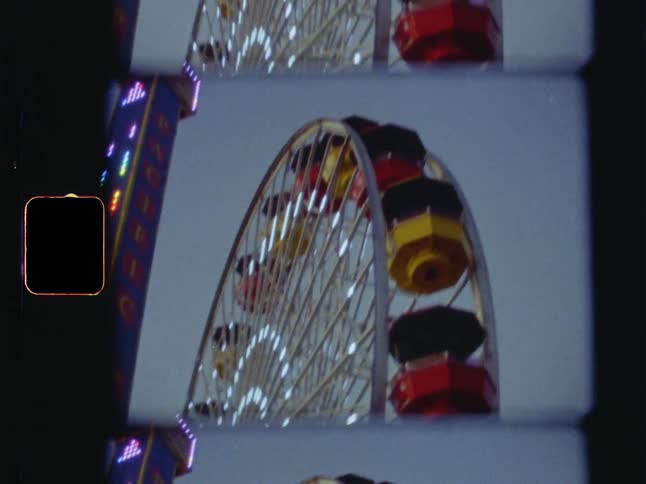 Lights shine and move along the spokes and frame of a ferris wheel
