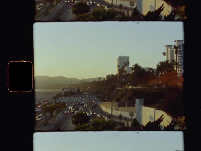 A busy highway with lots of cars by a city