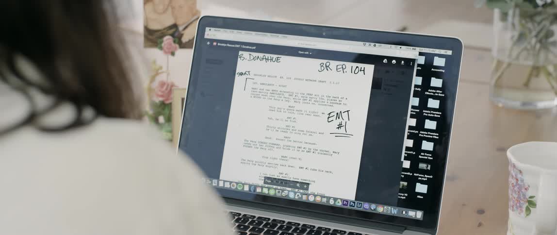 A woman sits and works on her laptop