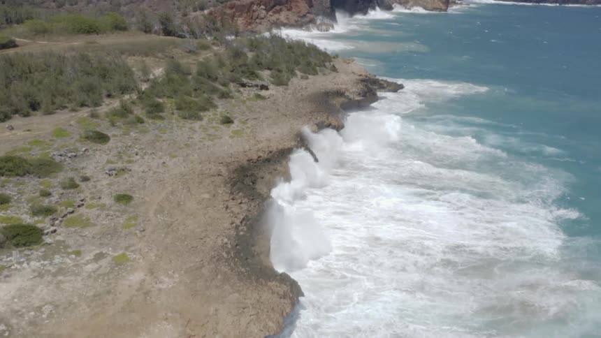 The ocean waves crashing up against land