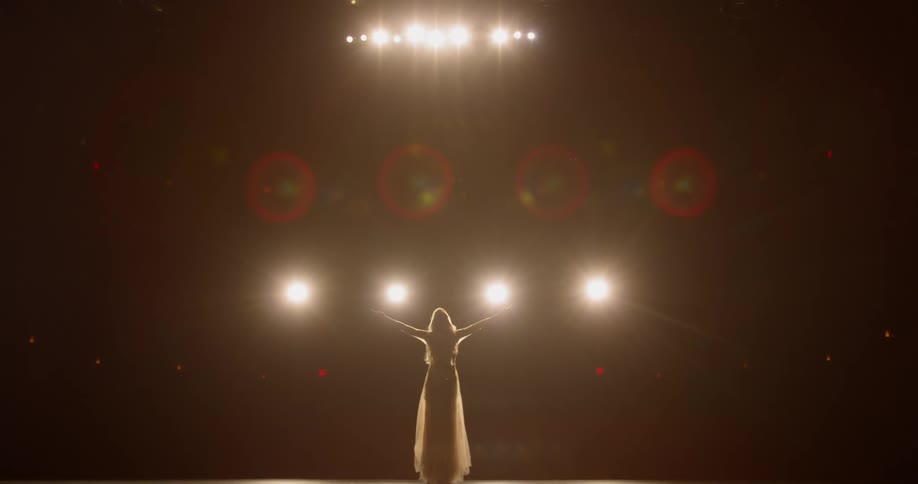 Spotlights shine on a female singer performing on stage