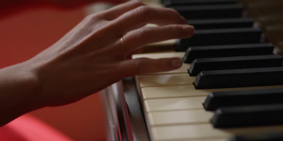 A woman plays a piano