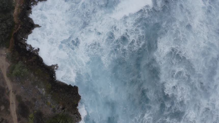 Ocean waves crash against the shore line