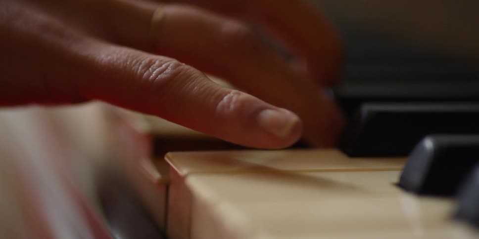 A hand plays the piano