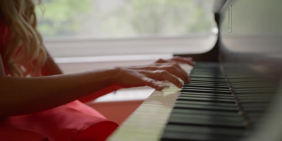 Woman plays piano in house