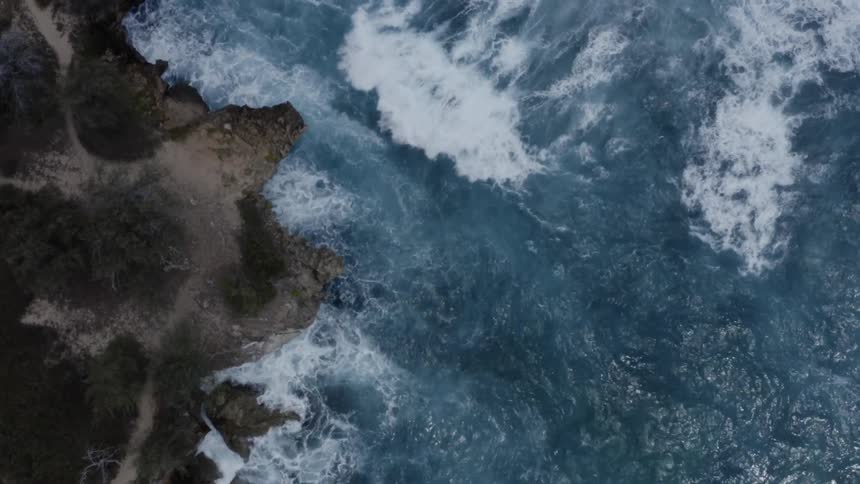 Turquoise ocean waves crash into a shoreline