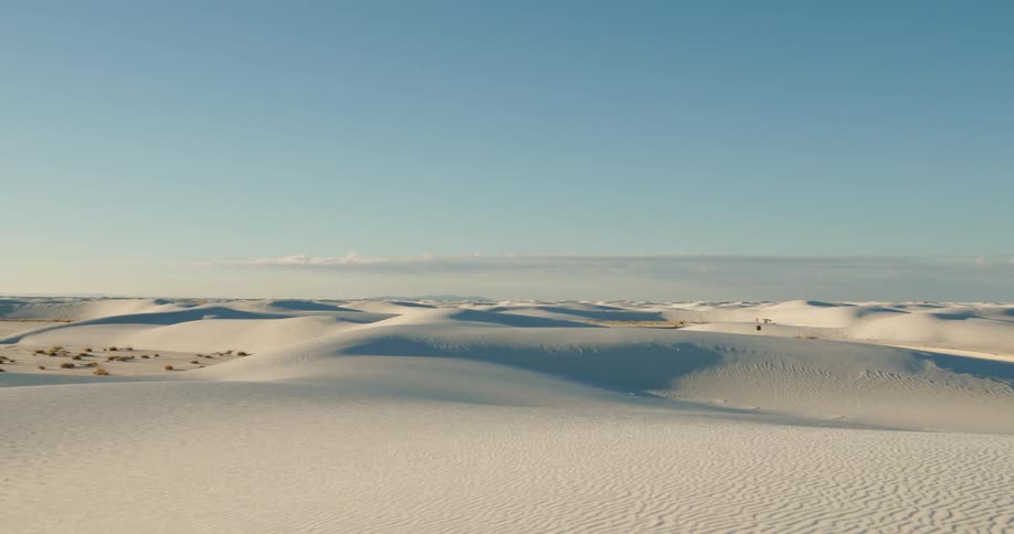 The desert sand sits under a blue sky