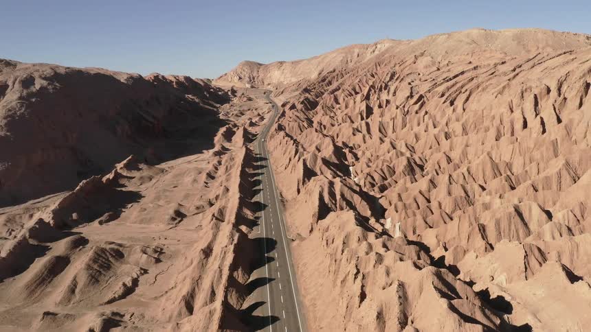A desert with many dunes and topographical areas with a highway