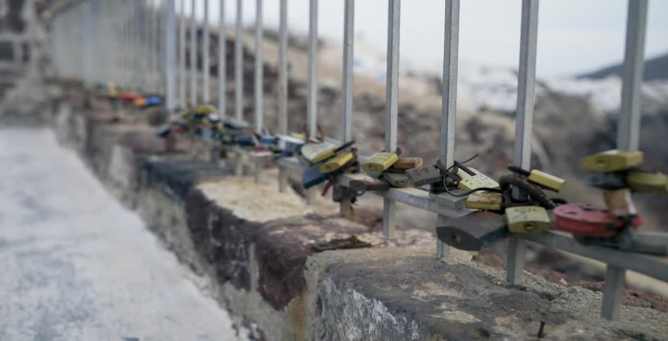 Padlocks attached to the rails of a bridge