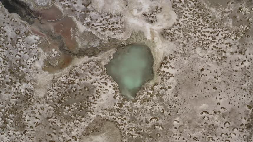 A body of water surrounded by ice and snow covered rocks and ridges