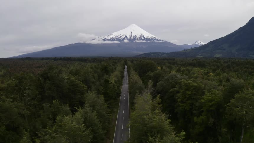 Aerial view of country road with mountain top in background