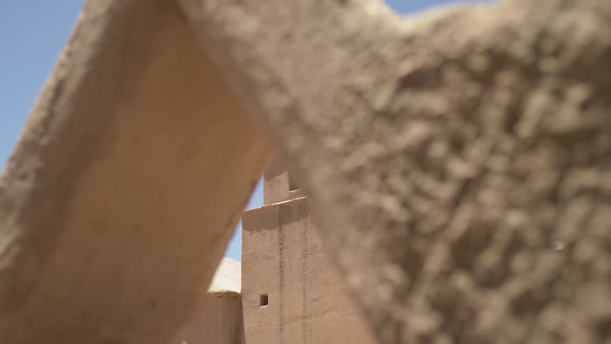 A concrete church steeple with a bell