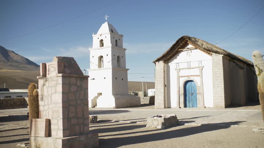 Cacti near church with mountain on the horizon