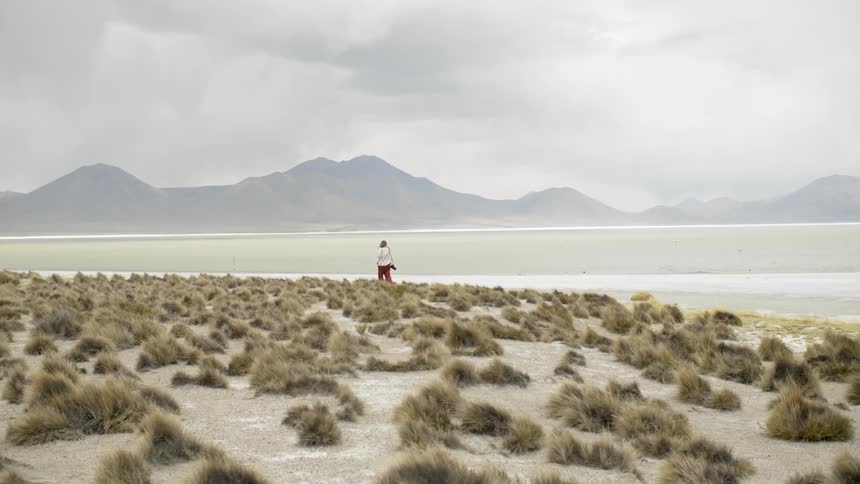 A woman walks along a quiet beach
