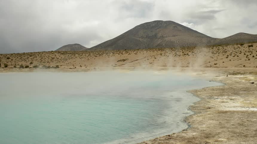 A lake streams in the desert with mountains visible in the background