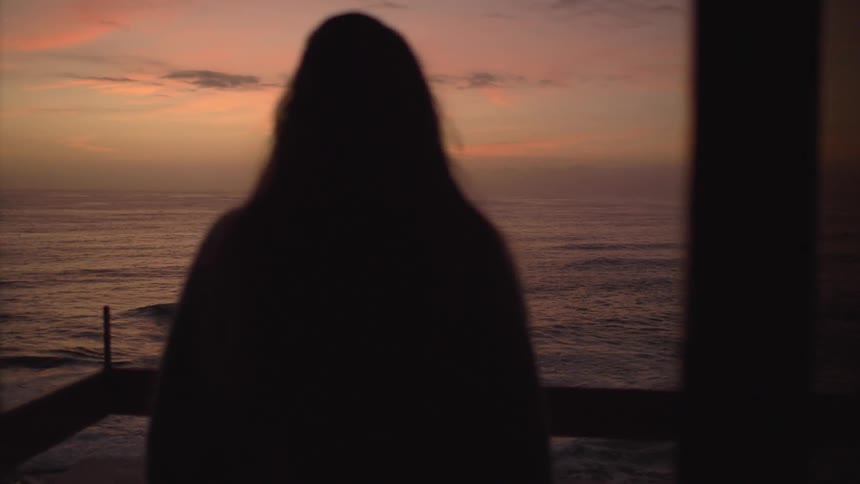 A person walking out to the ocean side balcony