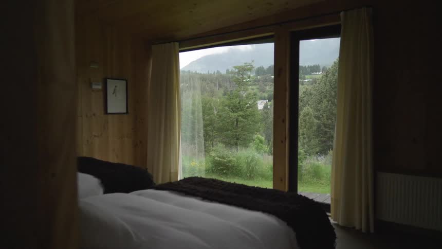 Entering a bedroom with two beds side by side and a large glass sliding door