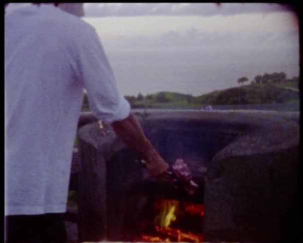 A group of men are cooking meat on a grill outdoors