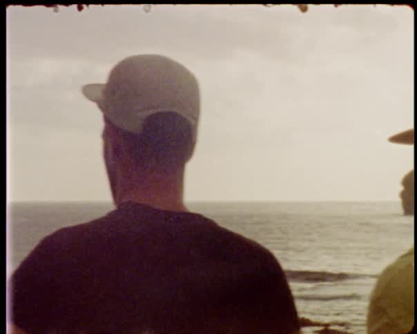 Girls and boys next to the ocean looking at waves