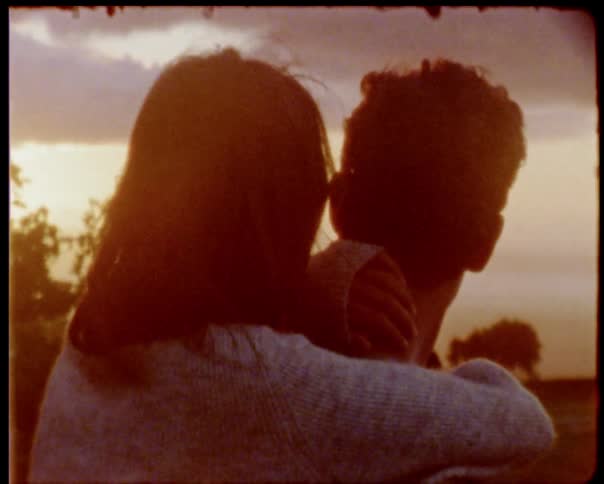 Man and woman hold each other at dusk